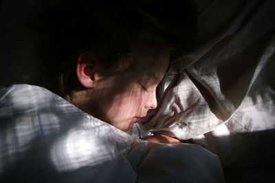 High angle view of woman sleeping on bed at home