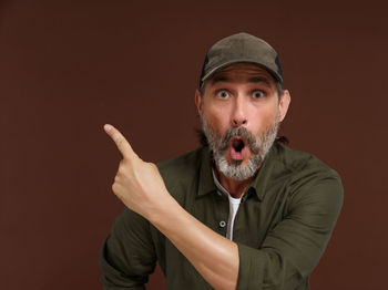Portrait of young man with face paint against gray background