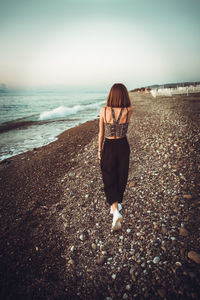 Full length of woman on beach against sky