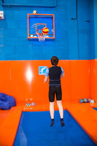 Rear view of boy playing on wall