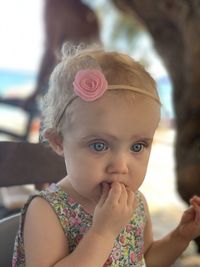 Close-up of cute baby girl having food while sitting on chair