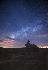 Silhouette man on desert against sky at night