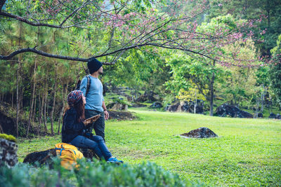 Rear view of men sitting on land