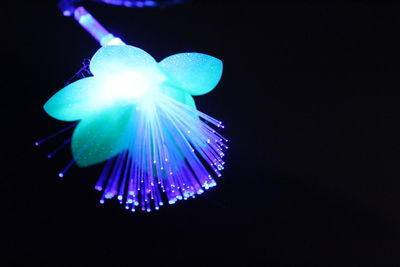 Low angle view of illuminated lighting equipment against black background