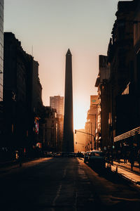 Silhouette column and buildings in city during sunset