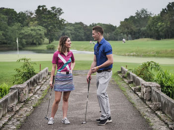 Full length of couple playing golf 