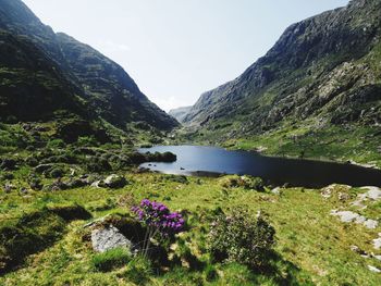 Scenic view of lake by mountain against sky