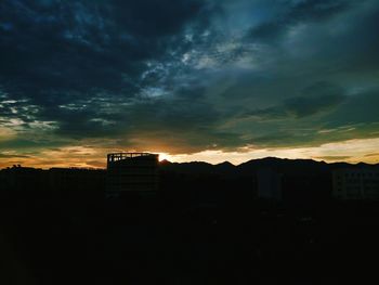 Buildings against cloudy sky at sunset