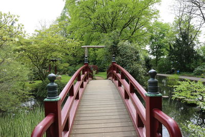 Footbridge over lake against trees