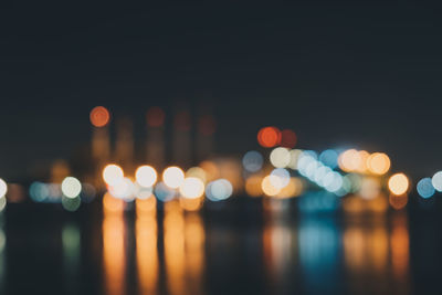 Defocused image of illuminated lights in city at night