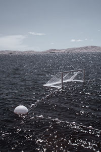 Buoy in sea against sky