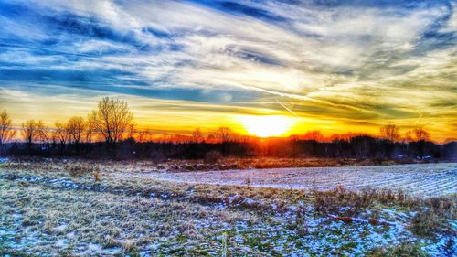 Snow covered field at sunset