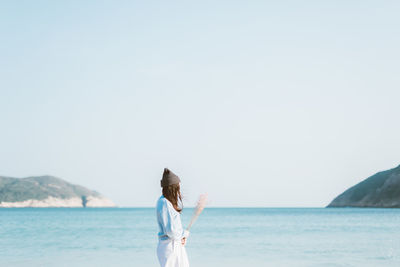 Side view of woman standing by sea