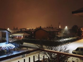 Illuminated houses against sky at night during winter