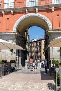 People on street amidst buildings in city