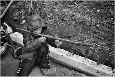 High angle view of boy playing with wooden stick in y