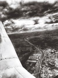 Aerial view of cityscape against cloudy sky
