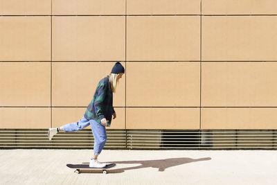 Side view of man standing on wall