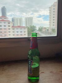 Glass of bottles on window of building