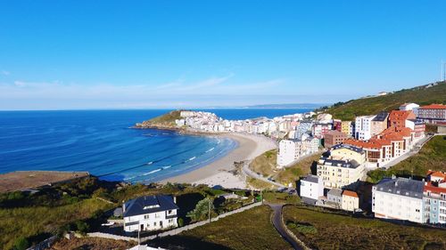 High angle view of townscape by sea against sky