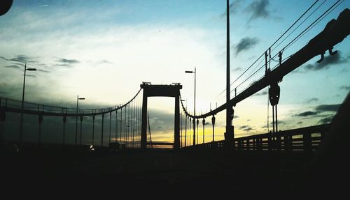 Low angle view of bridge against cloudy sky