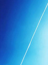 Low angle view of vapor trail against blue sky