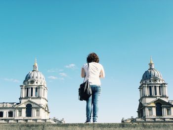 Low angle view of woman standing against clear sky