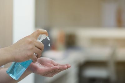 Midsection of woman holding camera at home