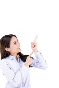Smiling young woman standing against white background