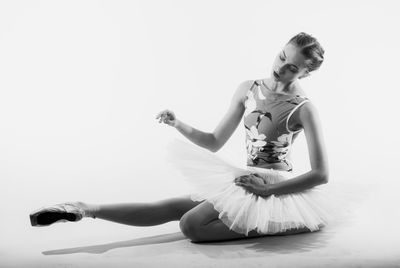 Young woman dancing against white background