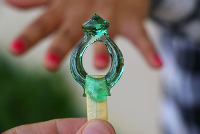 Cropped hand holding ring shaped lollipop