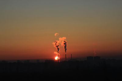 Smoke emitting from chimney against sky during sunset