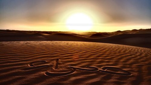 Sand dunes in desert against sky during sunset