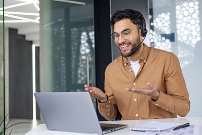 Young man using laptop while sitting in office