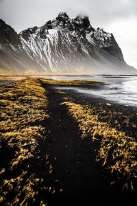 Scenic view of snowcapped mountains by sea against sky