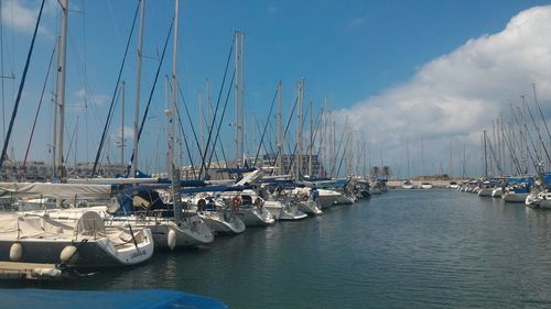 Sailboats moored in sea against sky