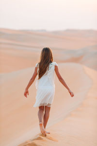 Rear view of woman walking on beach