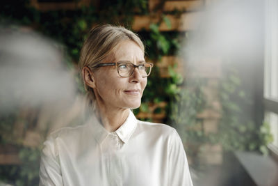 Businesswoman in green office looking out of window