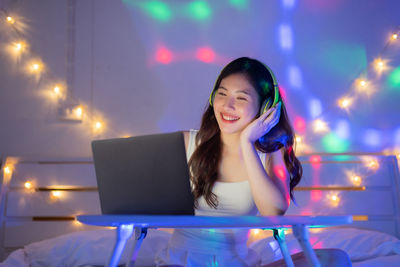 Young woman using mobile phone at night