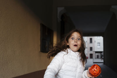 Scared girl with pumpkin basket in halloween
