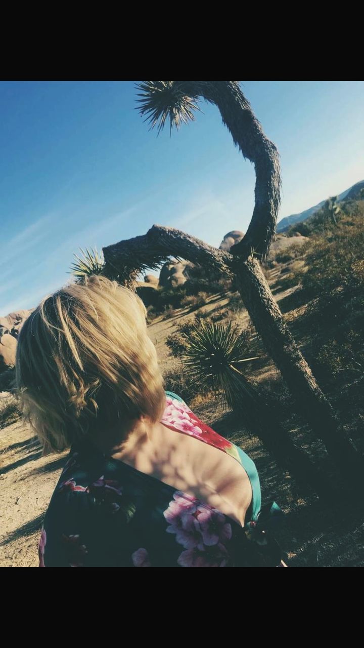 one person, leisure activity, plant, real people, nature, sky, lifestyles, day, transfer print, auto post production filter, tree, headshot, outdoors, sunlight, women, rear view, hair, land, beauty in nature, hairstyle