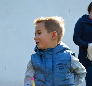 Cute boy looking away while standing outdoors