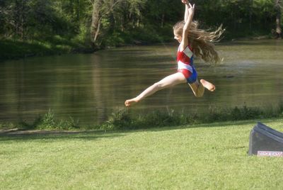 Full length of woman jumping on lake