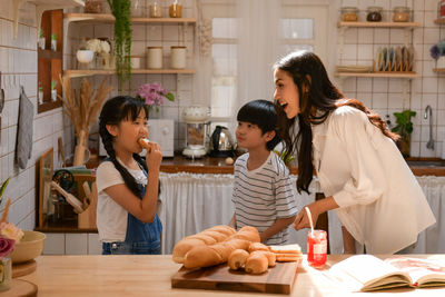 Family happy moments when children helping mom cook food in the kitchen.