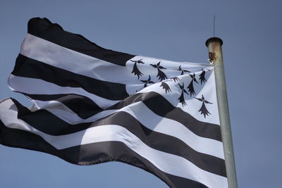 Low angle view of flag against blue sky