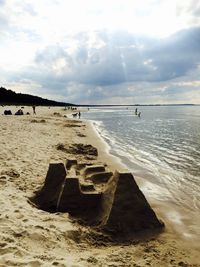 Sand castle at beach against sky