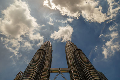 Low angle view of buildings against cloudy sky