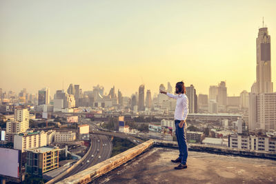 Businessman pointing at cityscape during sunset