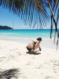 Rear view of man relaxing on beach