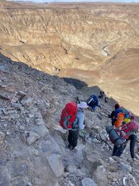 Rear view of people walking on rocks